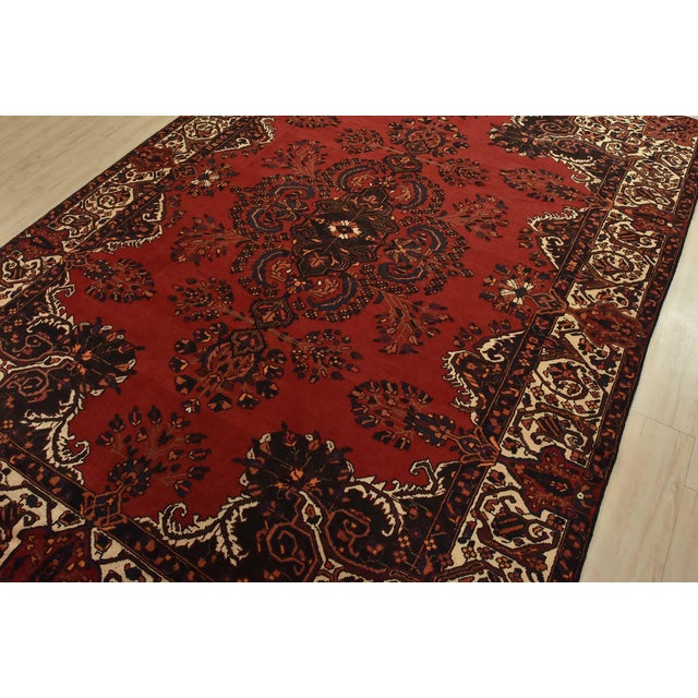 An authentic vintage traditional Baloch rug hand-knotted with fine wool and natural dyes. This rug features a central...
