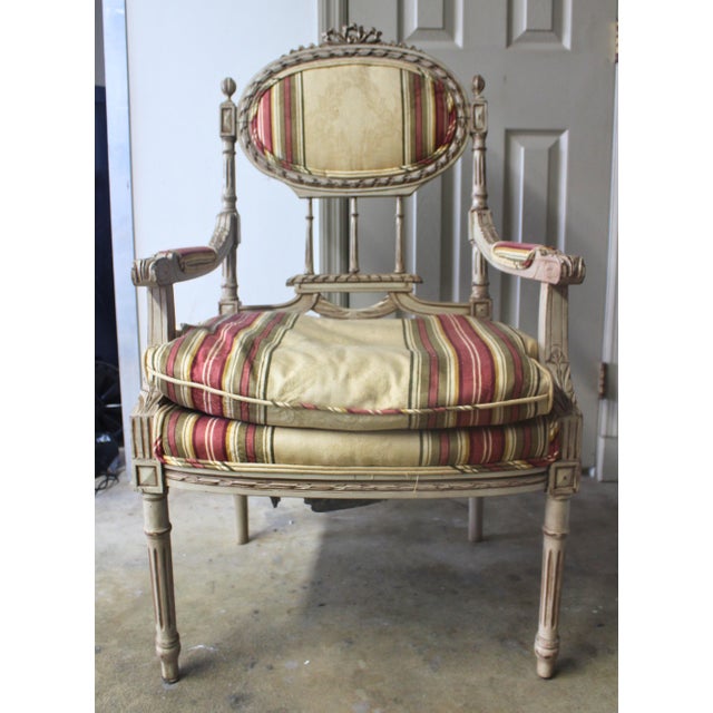 Elegant matched pair of early 20th century Louis XVI Revival armchairs distinguished by carved oval backs, fluted legs,...