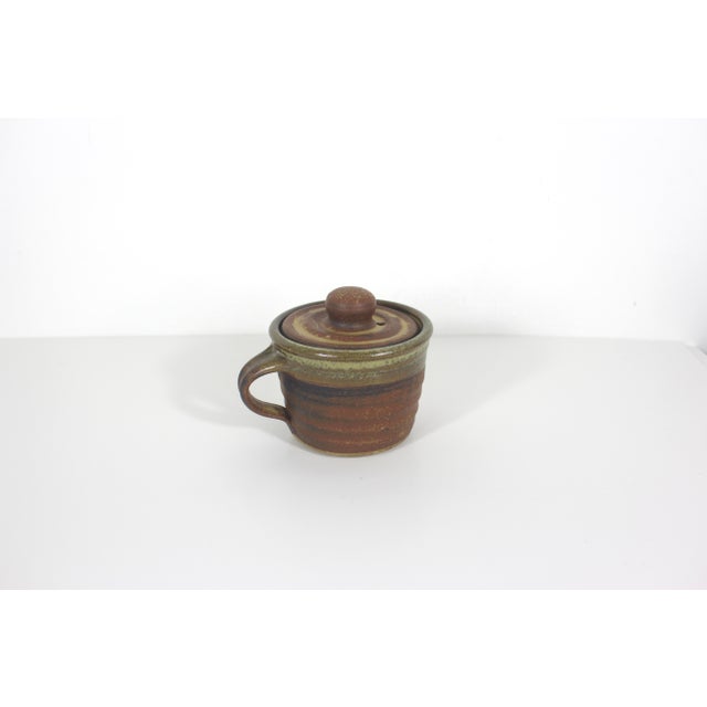 Vintage studio pottery mug with a lid. This is signed by the artist on the bottom. Excellent vintage condition. 5.25” wide...