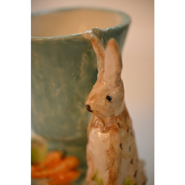 This charming cachepot or vase by Dana Gibson features a rabbit with carrots and lettuce standing guard against a sky blue...