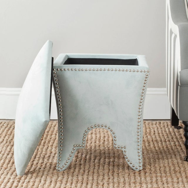 The chic ottoman recalls Moorish architecture with it's cutout arch motif studded with silver nailheads. Beautifully...