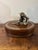A distinctive vintage leather decorative box attributed to Maitland Smith, featuring a sculptural cast metal monkey finial...
