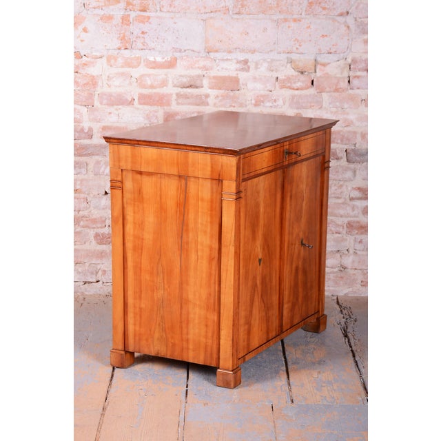 This elegant antique commode, functioning as a small cabinet, is an excellent example of middle-class furniture from the...
