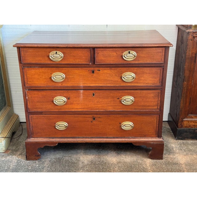 A 19th century English chest in warm mahogany, fitted with two short drawers over three long, each front outlined in fine...