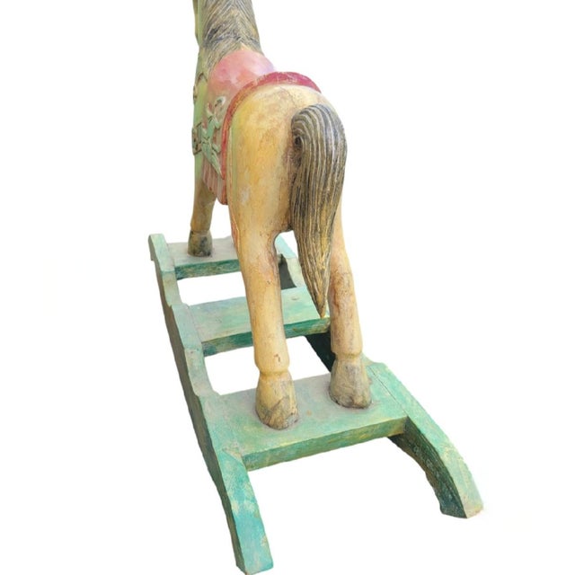 A fun and whimsical solid wood carved rocking horse. The horse has pretty pastel colors with a distressed antique glazed...