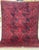 This striking Turkmen rug presents bold elongated octagonal medallions arranged in offset rows across a deeply saturated...