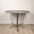 An Art Deco French wrought iron garden table with weathered green finish.