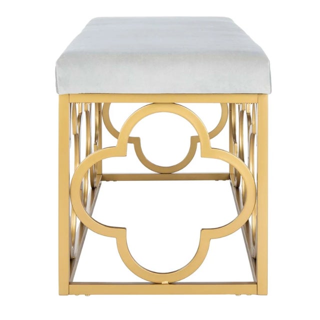 Glamorous modern bench with velvet upholstery and gold open quatrefoil design metal base.