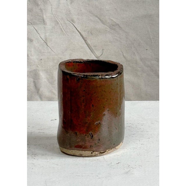 This vintage signed handmade glazed ceramic vase is adorned with a stunning red slip glaze, accented with other vibrant...