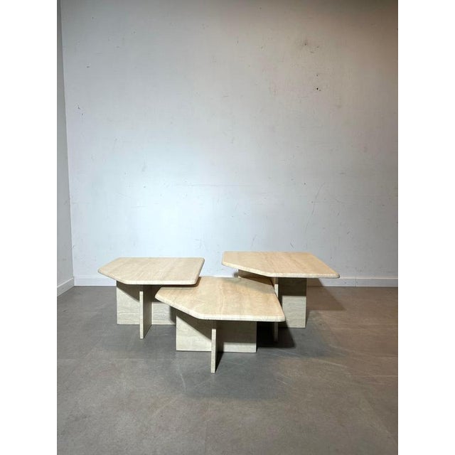 Beautiful vintage set of three nesting coffee tables in solid travertine. This sculptural trio features a refined...
