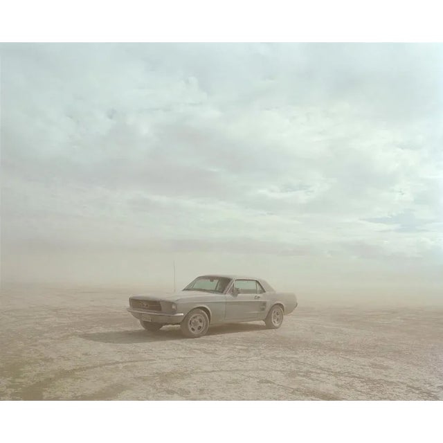 "Mustang, El Mirage, California" is an atmospheric C-Type print by Samuel Hicks. A classic American car, a Mustang, drives...