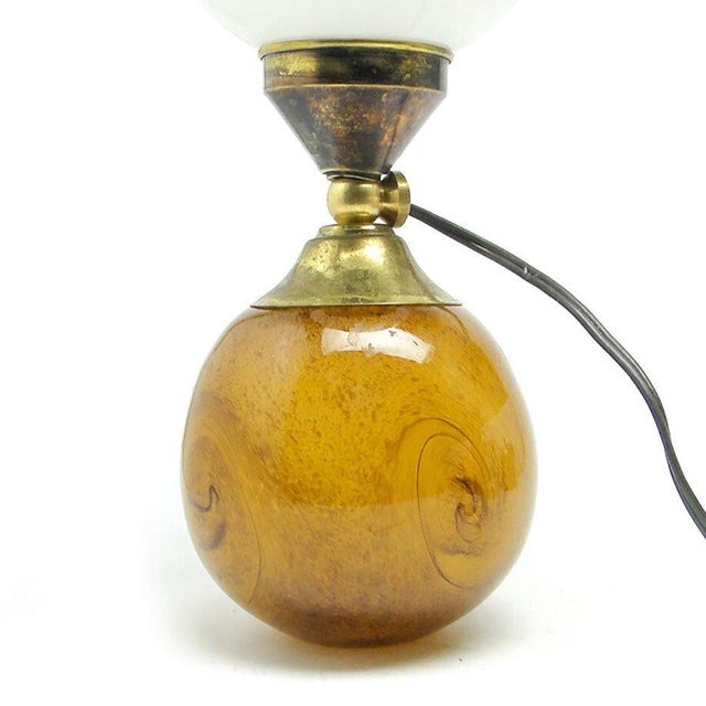 The table lamp comes from the 60s. It has a glass shade and metal mount and a glass base. It is preserved in very good...