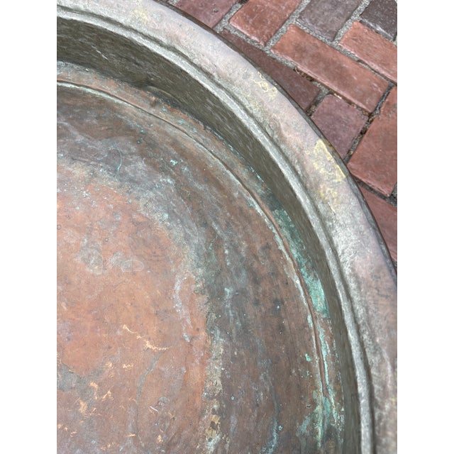 Antique artisan-crafted (26” round by 6.5” deep”) copper vessel. Sturdy with a lovely patina, it is ideal for use a...