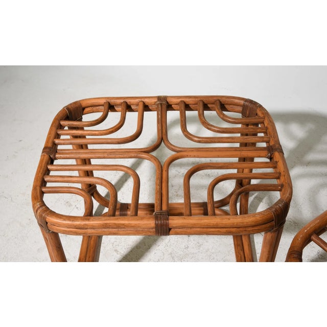 Pair of vintage rattan side tables featuring an intricate looped fretwork top design, hand bent and woven in a continuous...