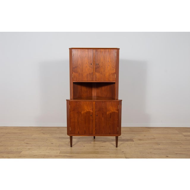 This tall corner cabinet was produced in Denmark in the 1960s and is an excellent example of Scandinavian Mid-Century...