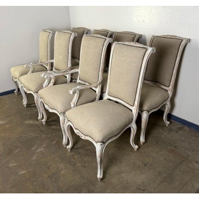 This elegant set of eight French dining chairs features classic Louis XV styling with gently curving cabriole legs, carved...