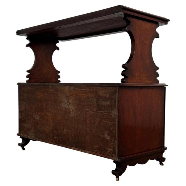 An elegant 19th-century English cupboard, finely crafted from mahogany and distinguished by its raised upper shelf,...