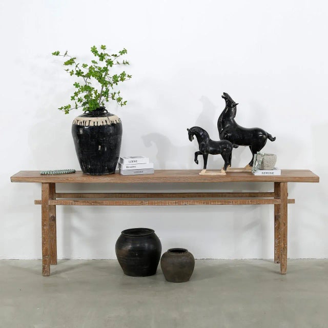 This vintage console table is crafted from solid elmwood and features a warm, weathered natural finish that highlights its...