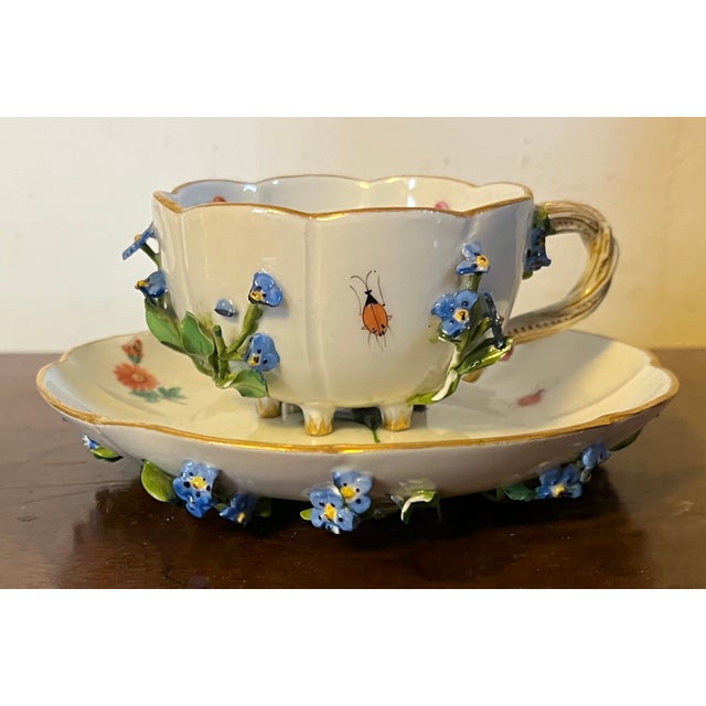 Antique Meissen porcelain tea cup and saucer decorated with applied forget-me-not flowers and hand painted insects....