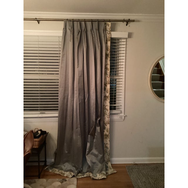 One pair of custom-made drapery in a silvery color. There’s a floral border on the leading edges and at the bottom. Made...