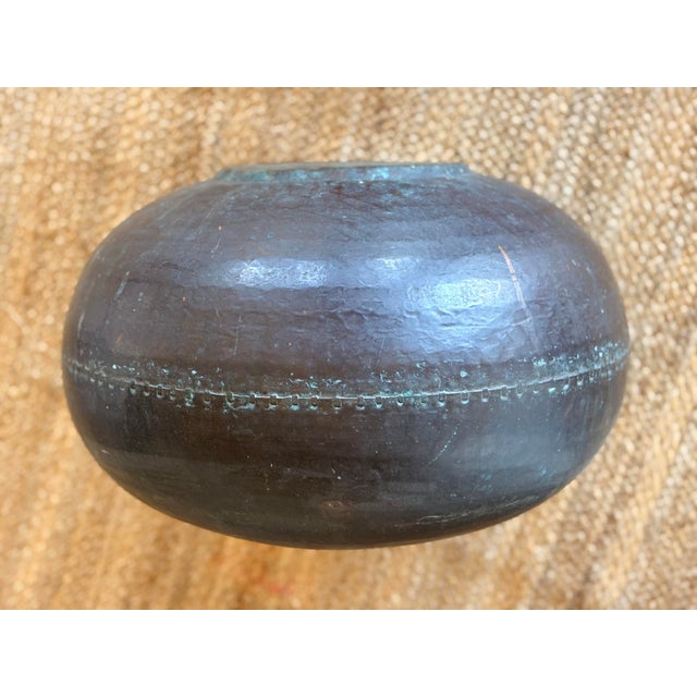 Antique hand-hammered copper vessel featuring a prominent, decorative brazed middle. The pot is built using traditional...