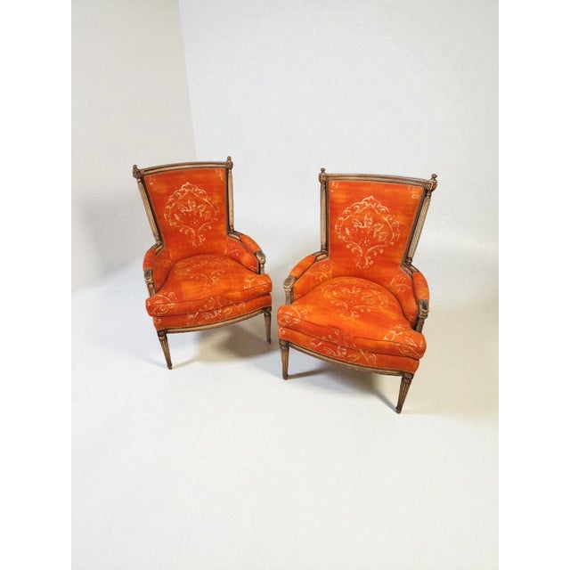 Pair of Louis XVI-style armchairs made in Italy in the 1960s. The armchairs are made of lacquered wood with an antiqued...