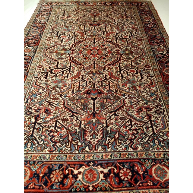 Vintage Persian Heriz in an allover pattern on an ivory color background with design colors in blue, green, red, navy, and...
