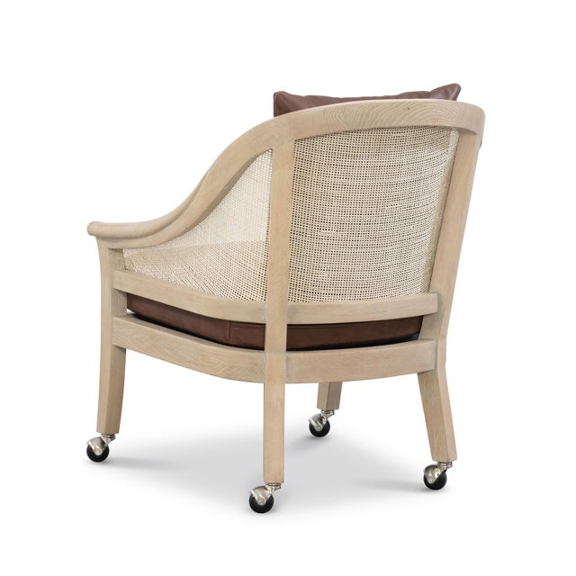 Cane and white oak game chair with Hickory Brown leather seat cushions. Nickel finished casters.