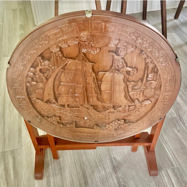 The image displays a pair of Chinese Carved Hardwood and Glass Tilt-Top Tea Table or Side Table, a type of antique...