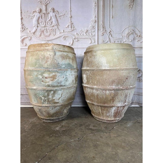 An extraordinary and highly decorative pair of monumental antique terracotta vessels, embodying the timeless beauty of...