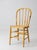 This antique Windsor-style chair features a classic rounded bow back, slender turned spindles, and a warm mustard-yellow...