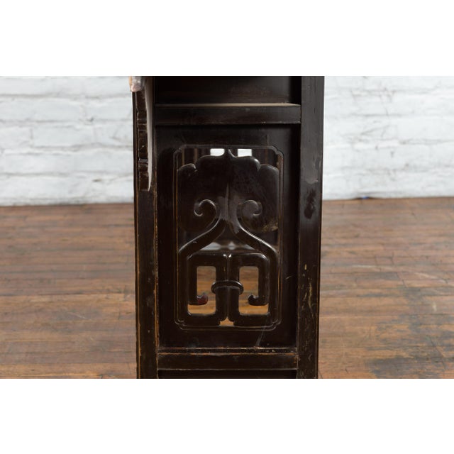 A Chinese Qing Dynasty period black lacquer altar console table from the early 19th century, with everted flanges, carved...