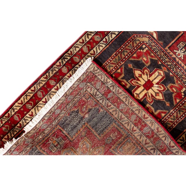 Beautiful vintage North West Persian hand-knotted wool runner with a red field. This piece has ivory, black, and gray...