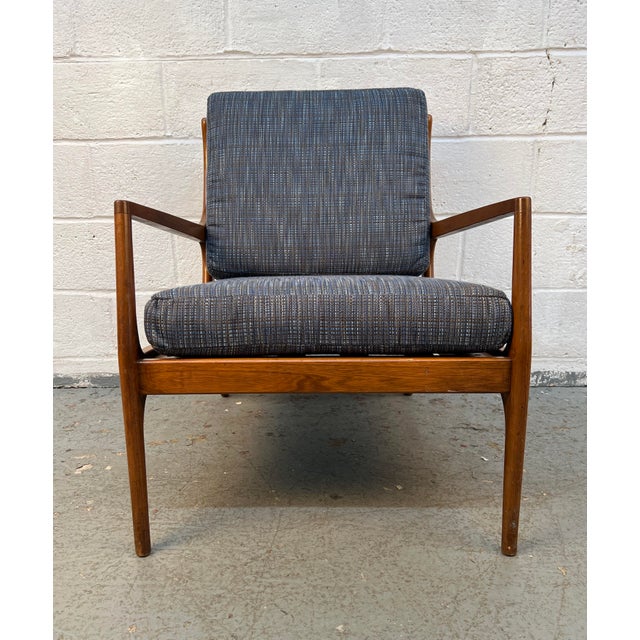 Timeless mid-century style to your space with this beautifully crafted walnut lounge chair. Featuring a solid walnut frame...