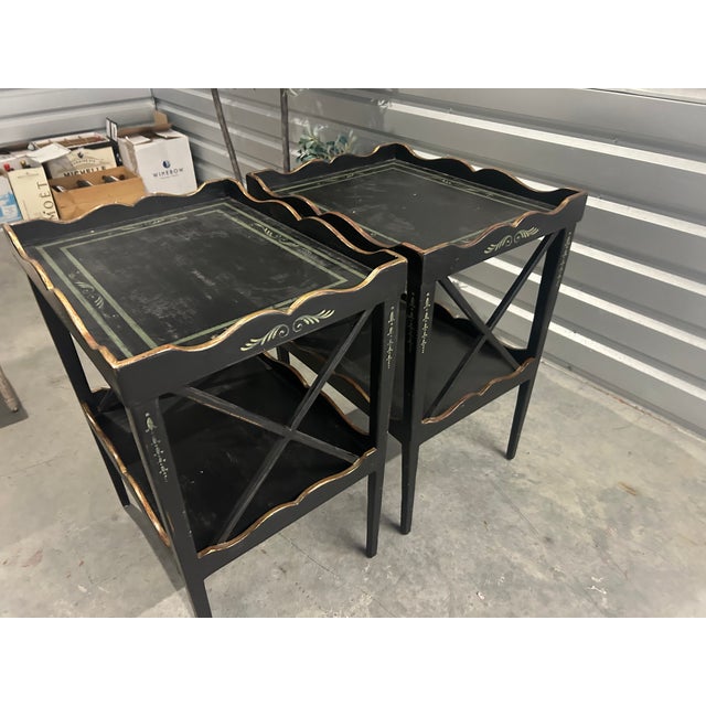 Elegant pair of Amy Howard two-tier side tables (end tables or nightstands) finished in a rich black paint with subtle...