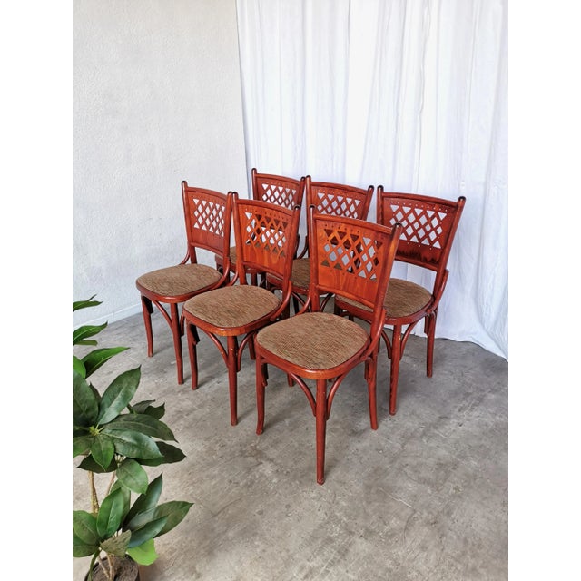 Vintage dining chairs were made in Italy in the 1980s. with a unique perforated backrest design and brown fabric seat....