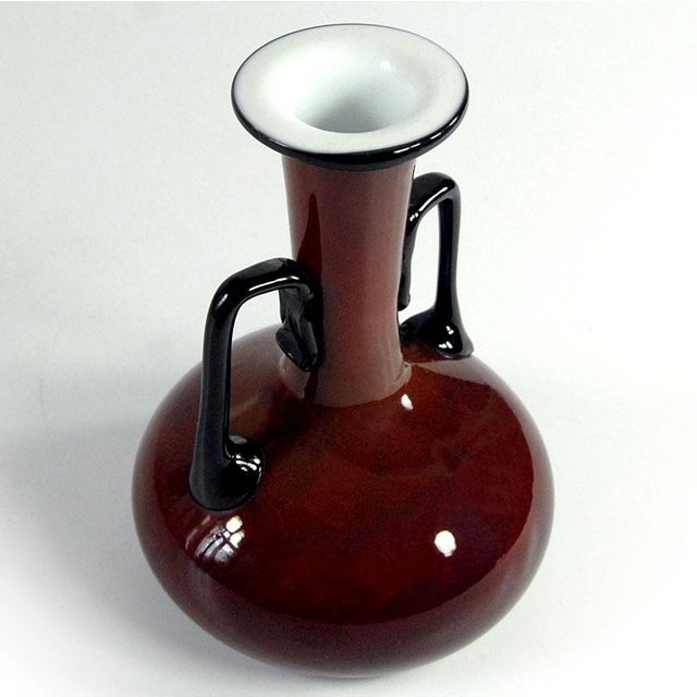A highly decorative bottle, handcrafted from colored, layered glass. Designed by Michael Povolný, it comes from the Loetz...