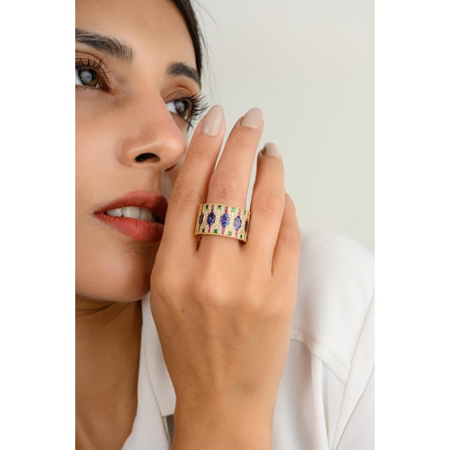 This stunning 14k gold wide band wedding ring features an array of brilliant multi-colored gemstones, exuding elegance and...