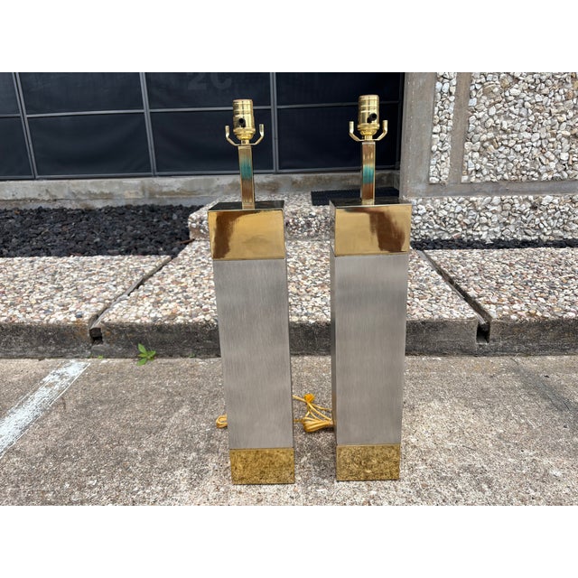Pair Of Frederick Cooper Stainless Steel And Brass Lamps. Offered is a large pair of Post-Modern table lamps with brushed...