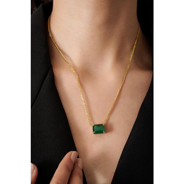 This solitaire pendant necklace features a 7.7-carat octagon emerald set in 14K yellow gold. The emerald measures 12.43 x...