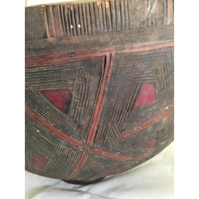 A large carved bowl from the Nupe or Hausa people from a large gourd. Incised geometric design with scattered red and...