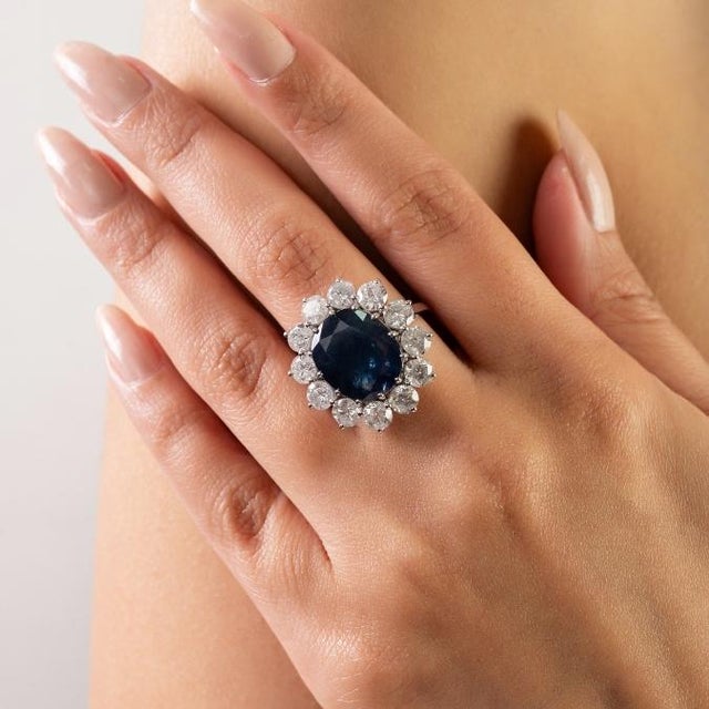 This elegant ring features 1 oval cut deep blue sapphire totaling 8.21 carats set in rich 18k white gold. The centerpiece...