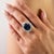This elegant ring features 1 oval cut deep blue sapphire totaling 8.21 carats set in rich 18k white gold. The centerpiece...