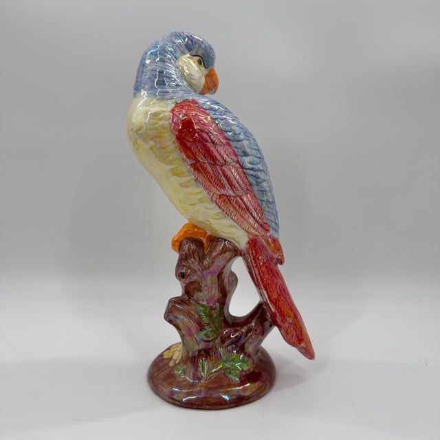 Hand-painted ceramic parrot sculpture featuring a luminous iridescent glaze and richly detailed featherwork. Perched atop...