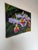 A vibrant 2003 oil on canvas painting by Ashrami depicting a lush arrangement of tropical orchids in vivid lavender, pink,...