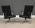 A pair of modern swivel black leather and chromed steel lounge chairs by Davis Furniture with black webbed backs and 5...