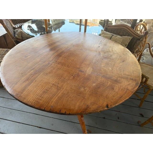 This Antique French Fruitwood Round Kitchen Dining Table is a beautifully crafted piece that exudes elegance and charm....