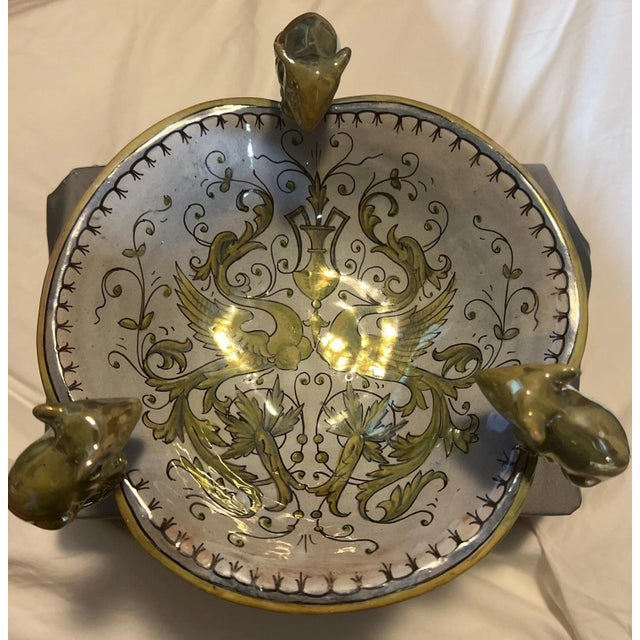 A Gualdo Tadino ceramic centerpiece bowl from Italy, on a white and cream ground with blue, green, and yellow floral...