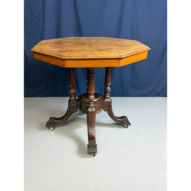 This Victorian-era octagonal centre table with removable top, created around 1900, features a burr walnut finish. The...