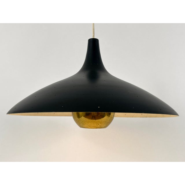 Extremely rare, highly decorative and elegant mid-century modern pendant lamp or hanging light with perforated shade and...